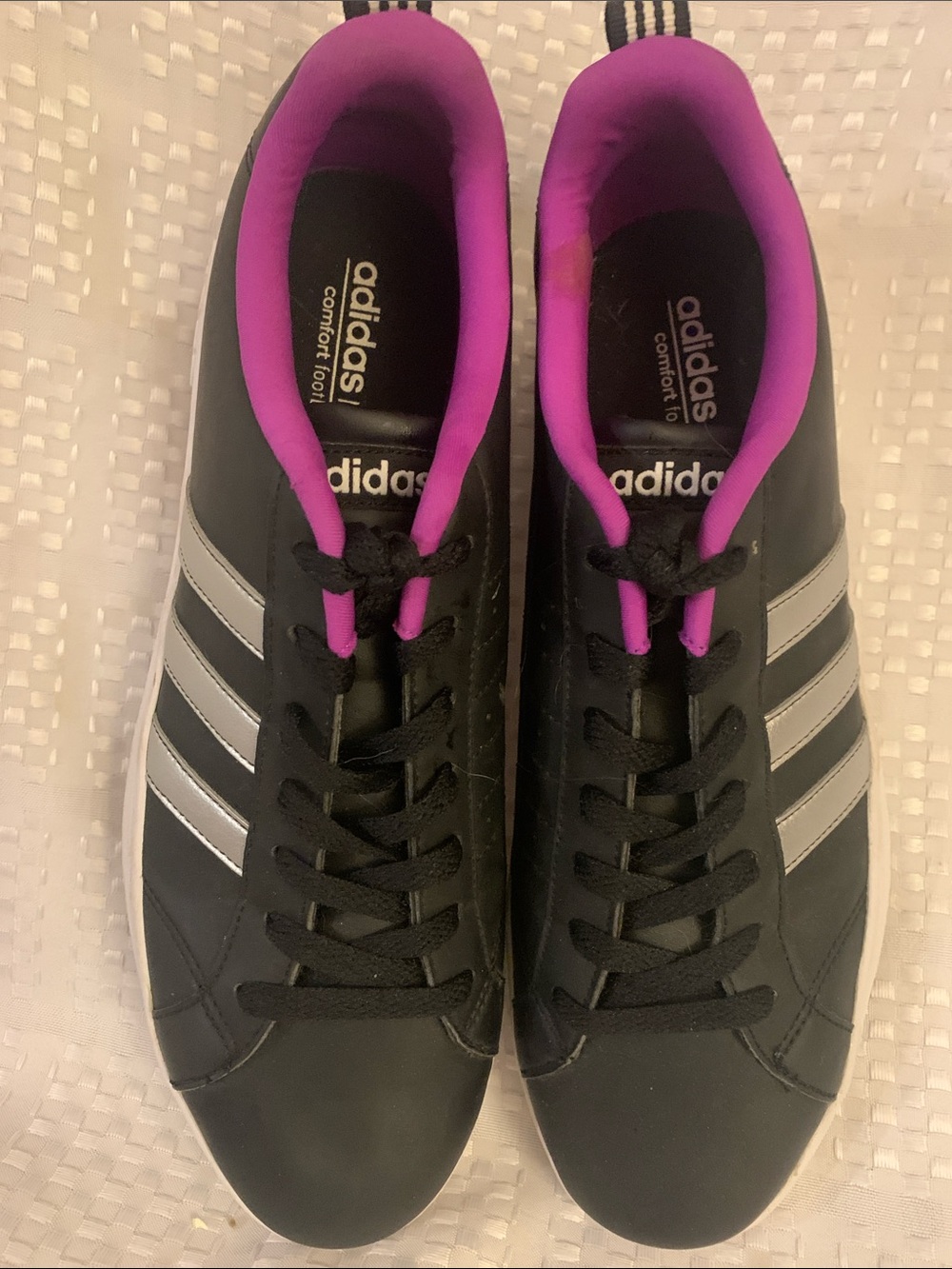 Adidas women’s black sneakers with silver stripes and pink lining, size 10.